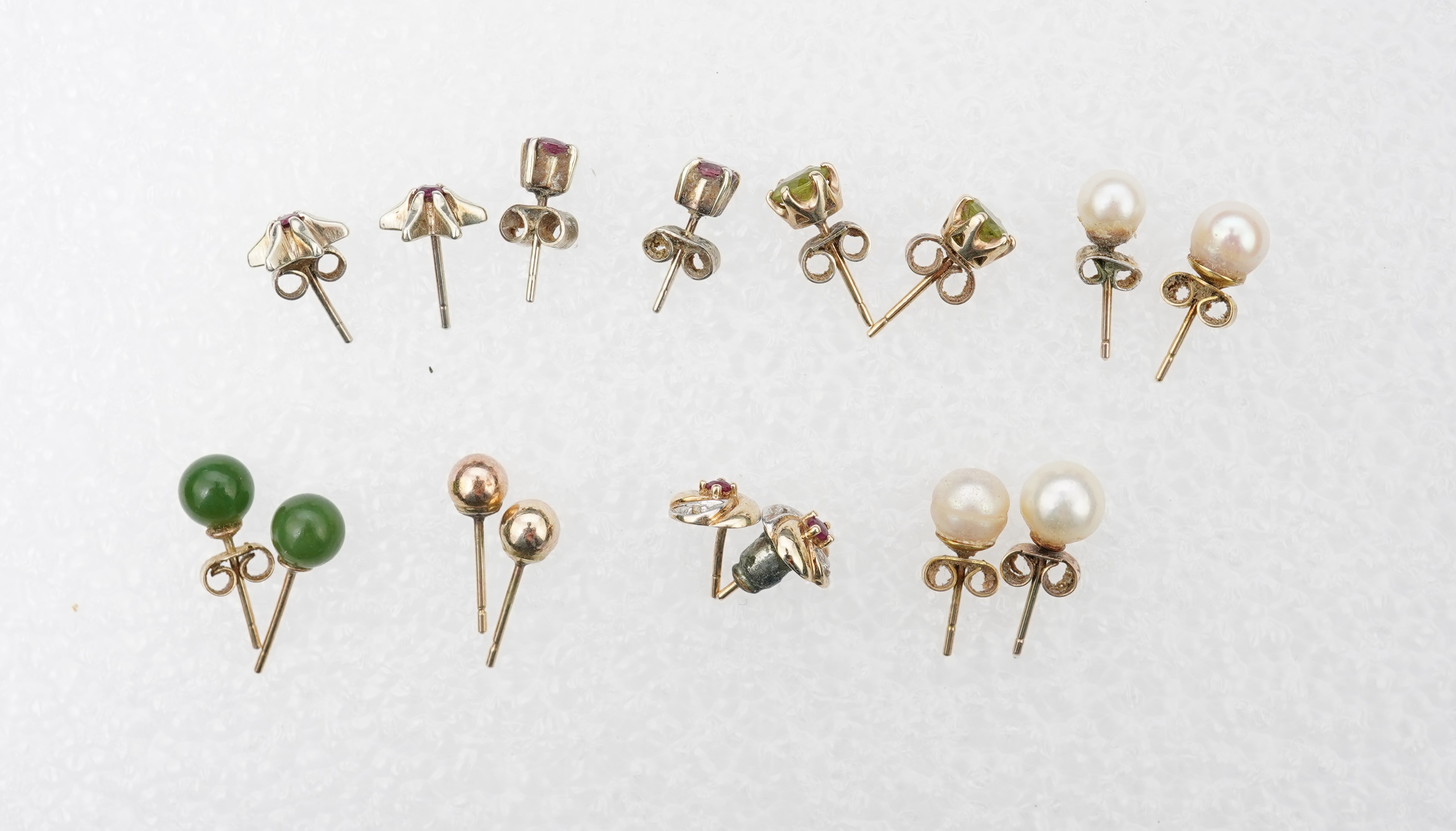 Four assorted pairs of 9ct and gem set ear studs including peridot and cultured pearl, together with three other assorted pairs yellow or white metal ear studs and two odd ear studs.